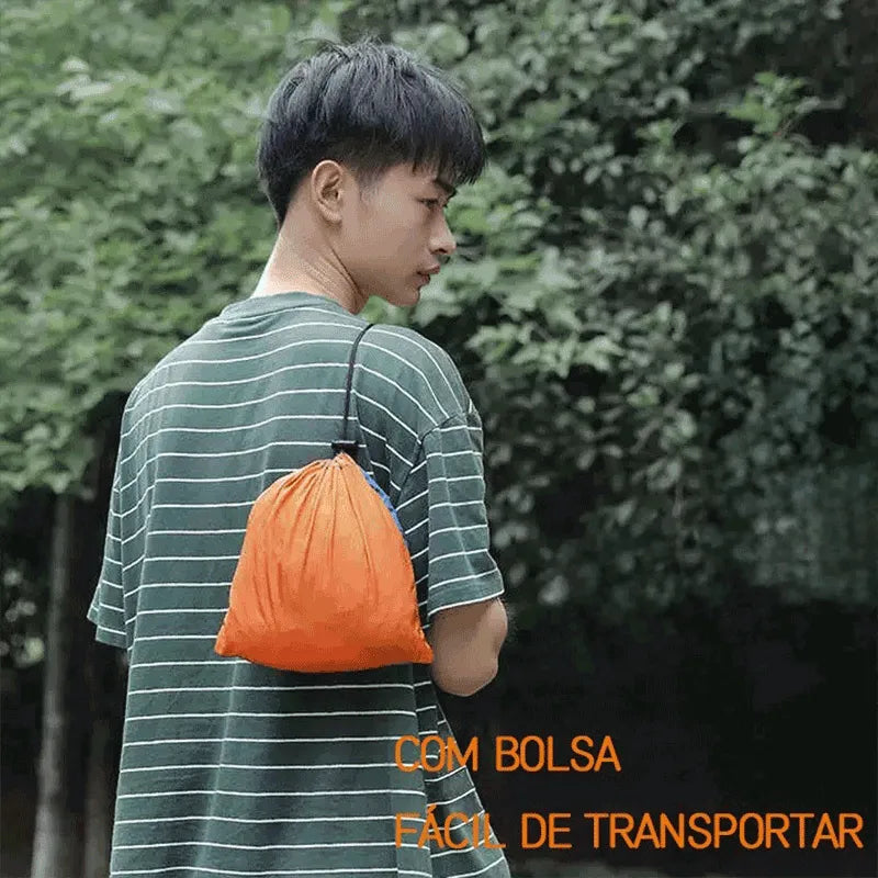 Homem carregando a rede de camping na bolsa compacta, enfatizando a portabilidade extrema e a conveniência para transporte.