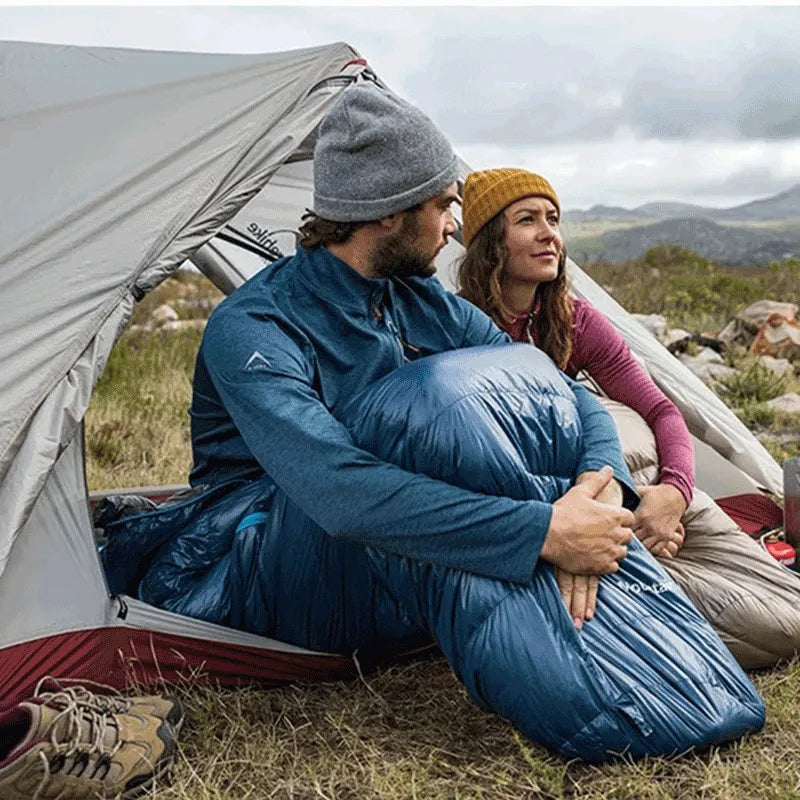 Casal aproveitando a vista através das portas duplas, que garantem ventilação superior e conforto em acampamentos longos.