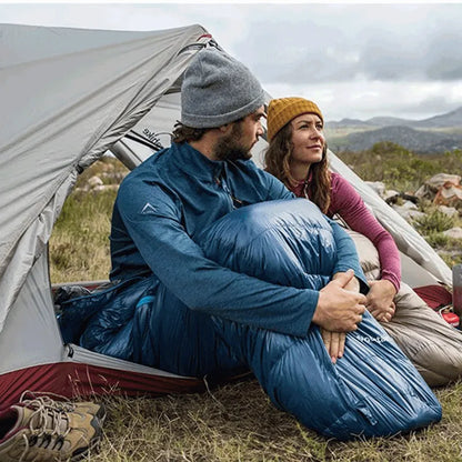 Casal aproveitando a vista através das portas duplas, que garantem ventilação superior e conforto em acampamentos longos.
