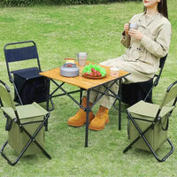 Cadeira Cooler utilizada em conjunto com mesa em cenário de camping, ideal para uso em grupo e organização dos itens.
