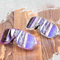 Dois óculos lado a lado (Pink e Transparente), reforçando o estilo performance e a durabilidade dos materiais em cores modernas.