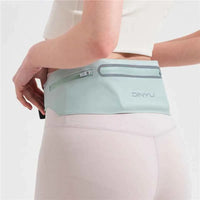 Usuária com a pochete na parte traseira, reforçando a segurança antifurto e o conforto do design slim para performance.