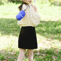 Usuária carregando a rede compactada na bolsa compacta azul, enfatizando a portabilidade extrema e a conveniência.