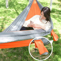 Usuária relaxando na rede Casal, com o bolso lateral visível, promovendo conforto e organização para itens pessoais.