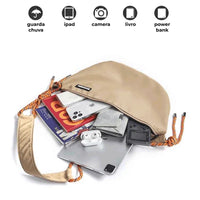 Vista interna da bolsa, mostrando a capacidade para iPad, câmera e power bank, ideal para organização de eletrônicos.