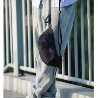 Usuário com a shoulder bag em ambiente urbano, reforçando a portabilidade e o conforto no estilo casual.