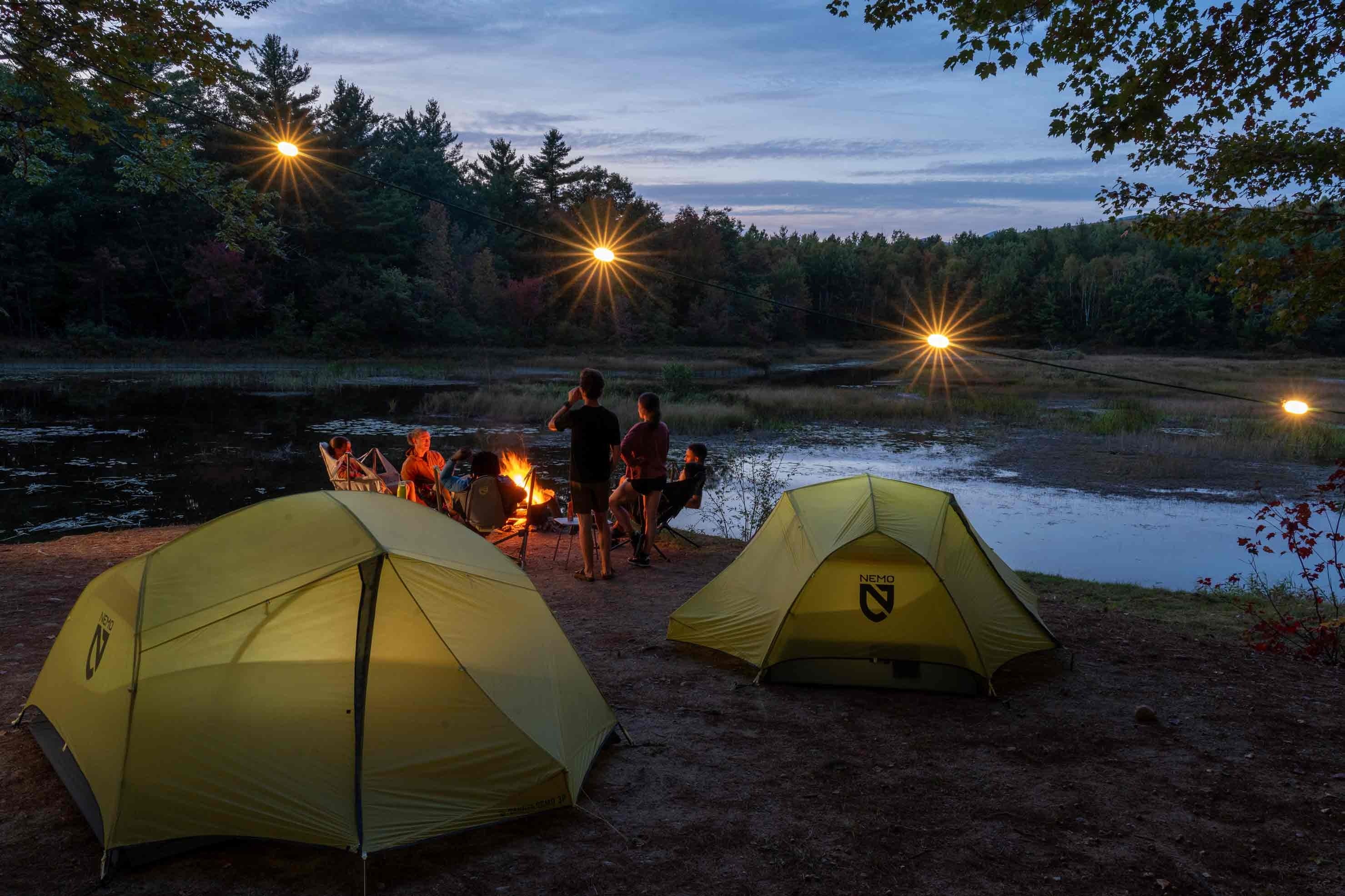 Grupo de aventureiros com mochilas atravessando pedras em um rio de montanha — espírito de liberdade e natureza da Cultura Puff