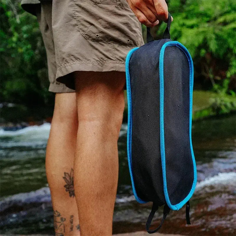 Bolsa de transporte compacta da cadeira azul sendo segurada na mão trilha