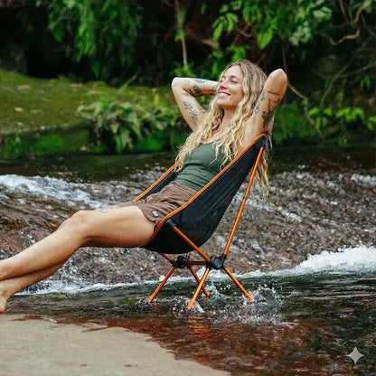 Cadeira Camping Dobrável Compacta - Sunset modelo usando tranquilo na cachoeira