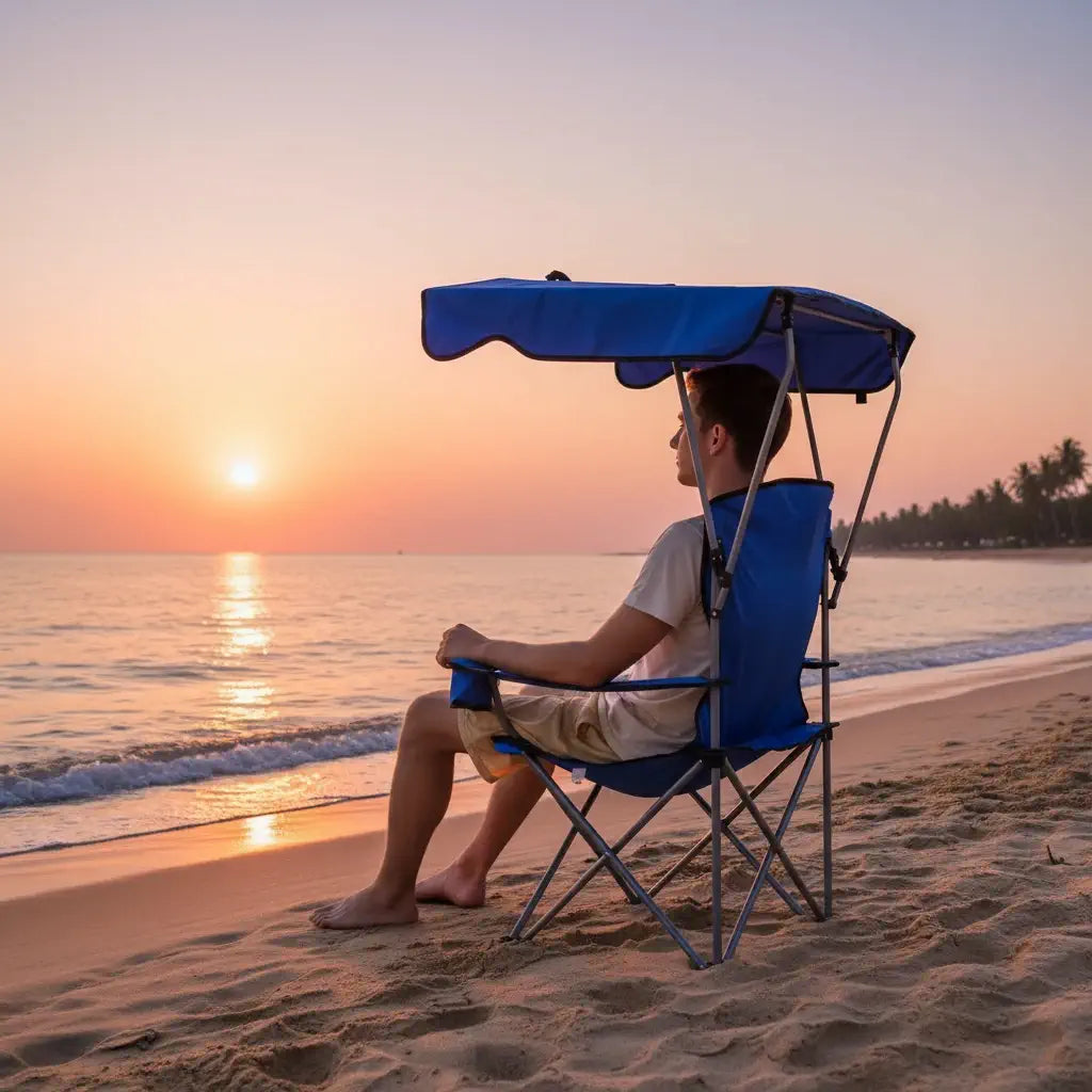 Homem relaxando na cadeira dobrável com guarda-sol integrado, garantindo proteção solar e conforto em acampamento.
